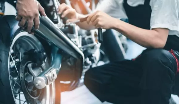 Mécaniciens autour d'une moto en entretien révision